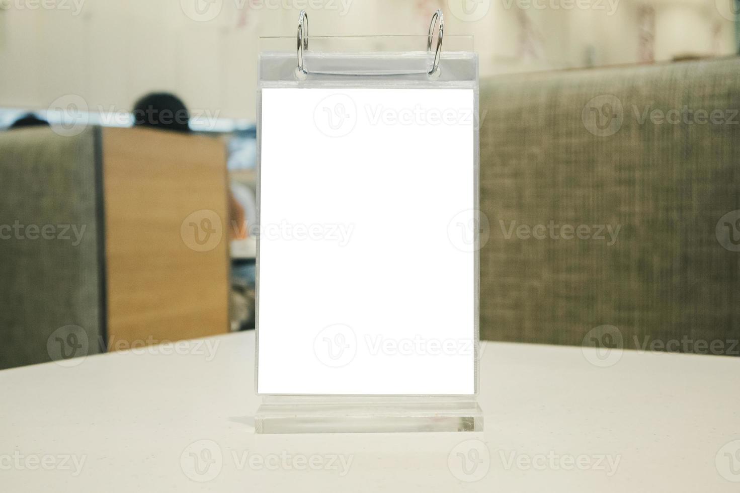 Mockup empty white label menu frame on table with cafe restaurant interior background photo