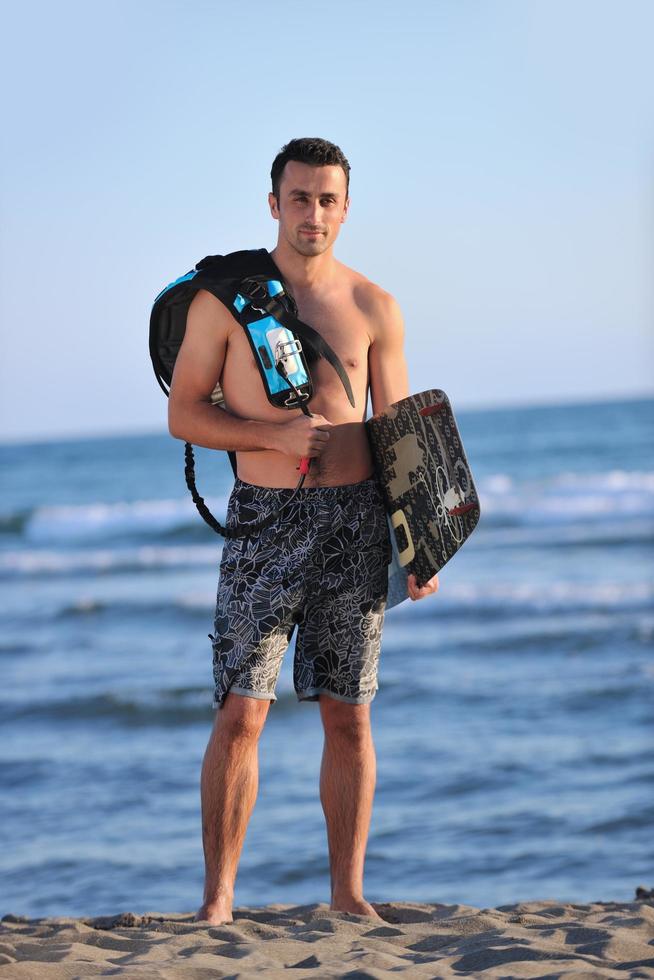 Portrait of a young  kitsurf  man at beach on sunset photo