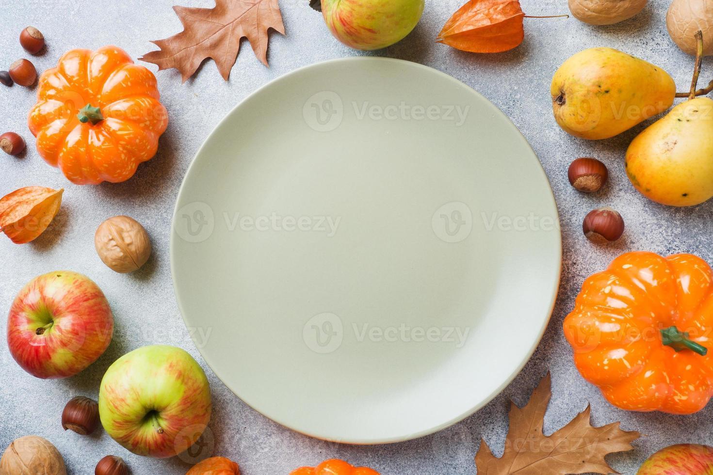 Autumn background with yellow leaves, pumpkins apples pears and nuts. Copy space. photo