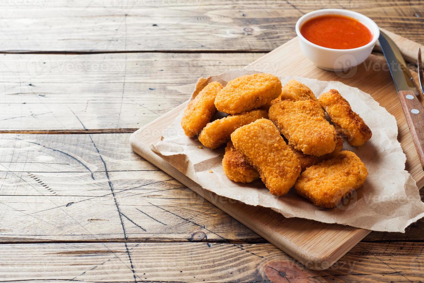 chicken nuggets with tomato sauce on wooden background. Copy space. photo