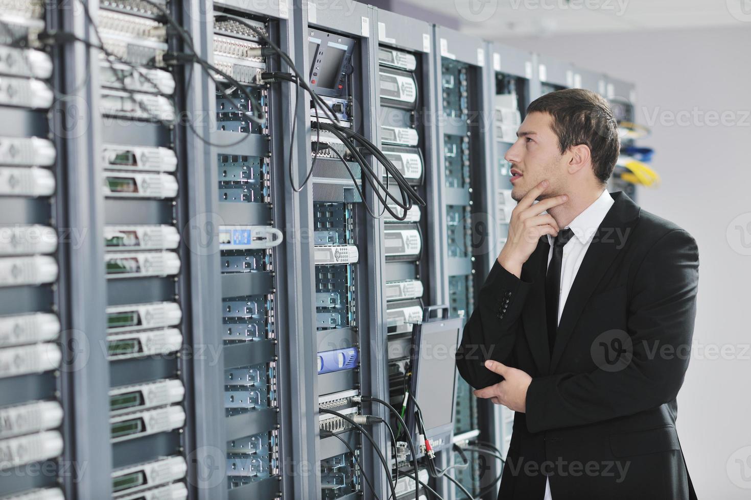 young engeneer in datacenter server room photo