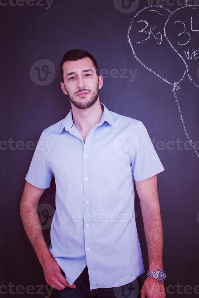 portrait of man in front of black chalkboard photo