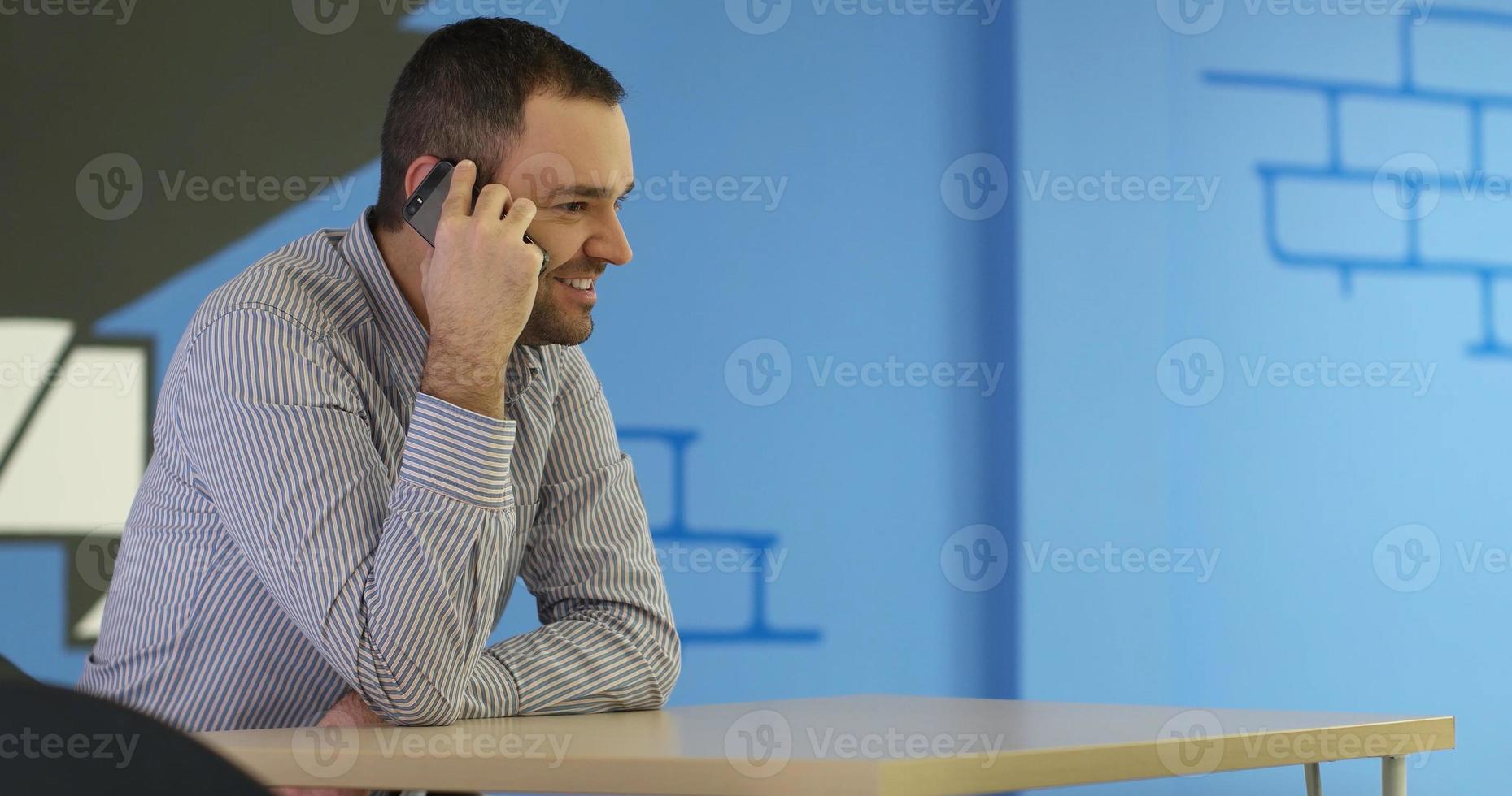 Empresario de alto nivel que usa un teléfono celular en la oficina de Stratup foto