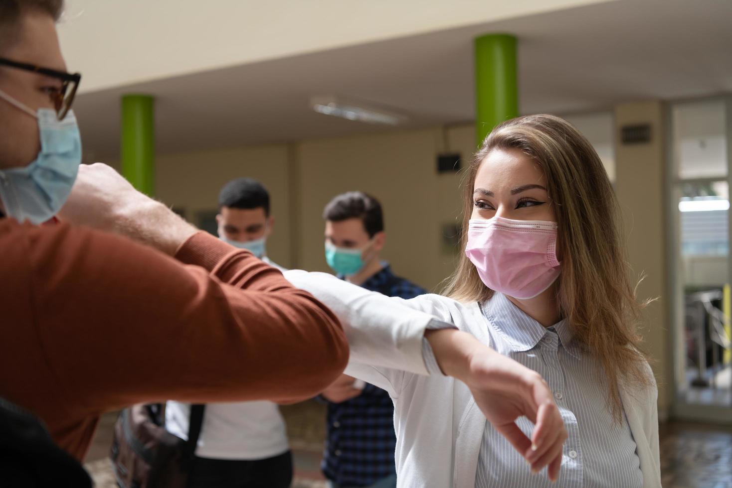 estudiantes saludando el nuevo apretón de manos normal de coronavirus y golpes de codo foto