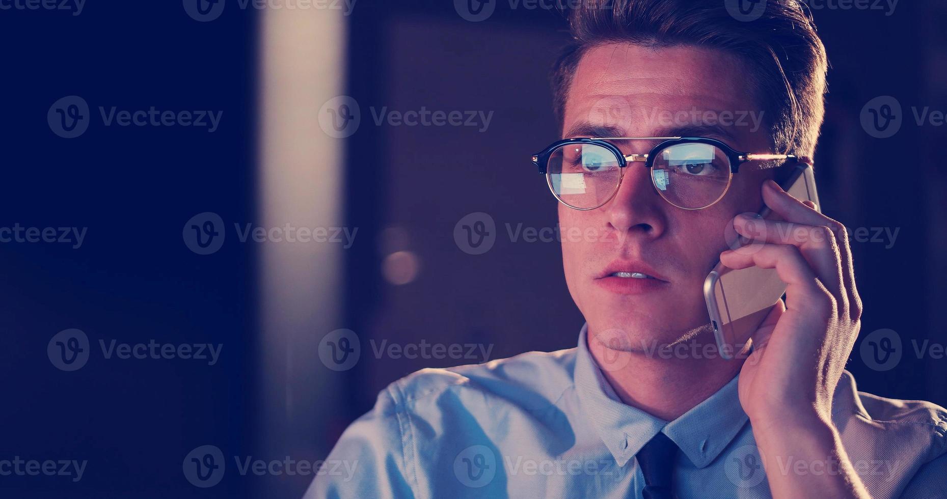 man using mobile phone in dark office photo