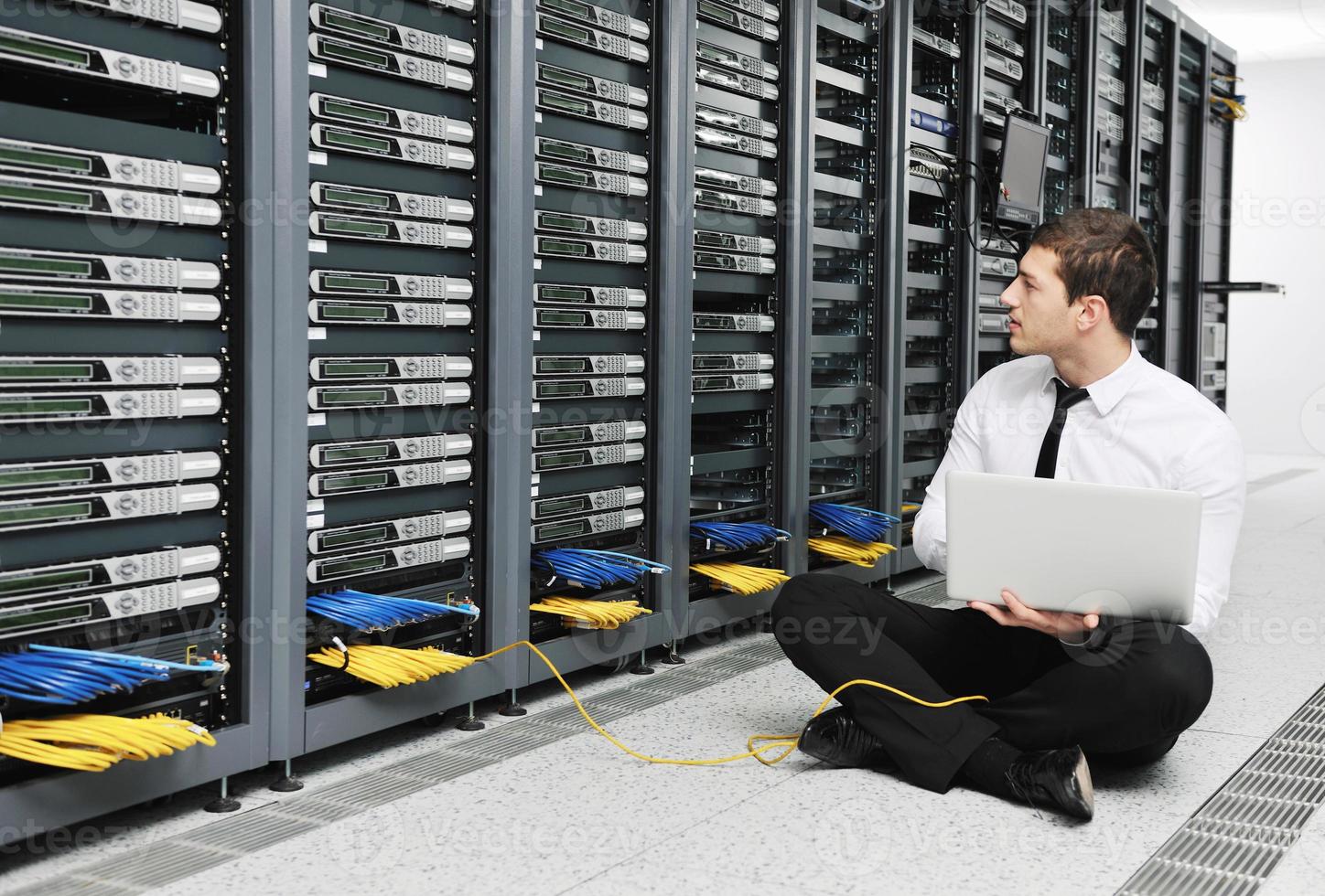 businessman with laptop in network server room photo