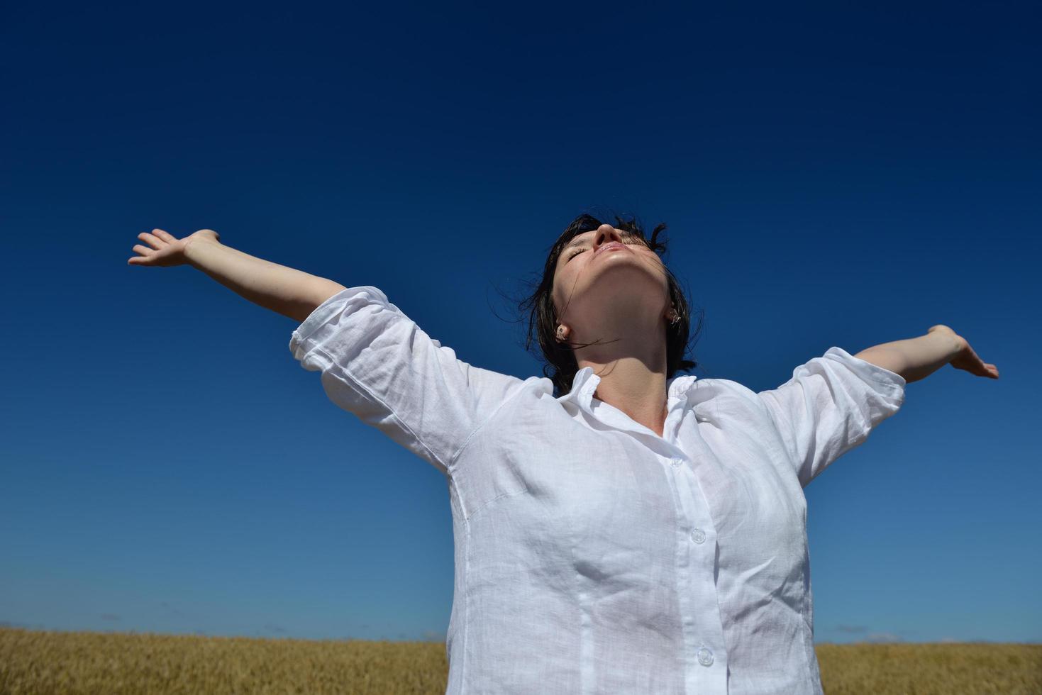 young woman in wheat field at summer photo