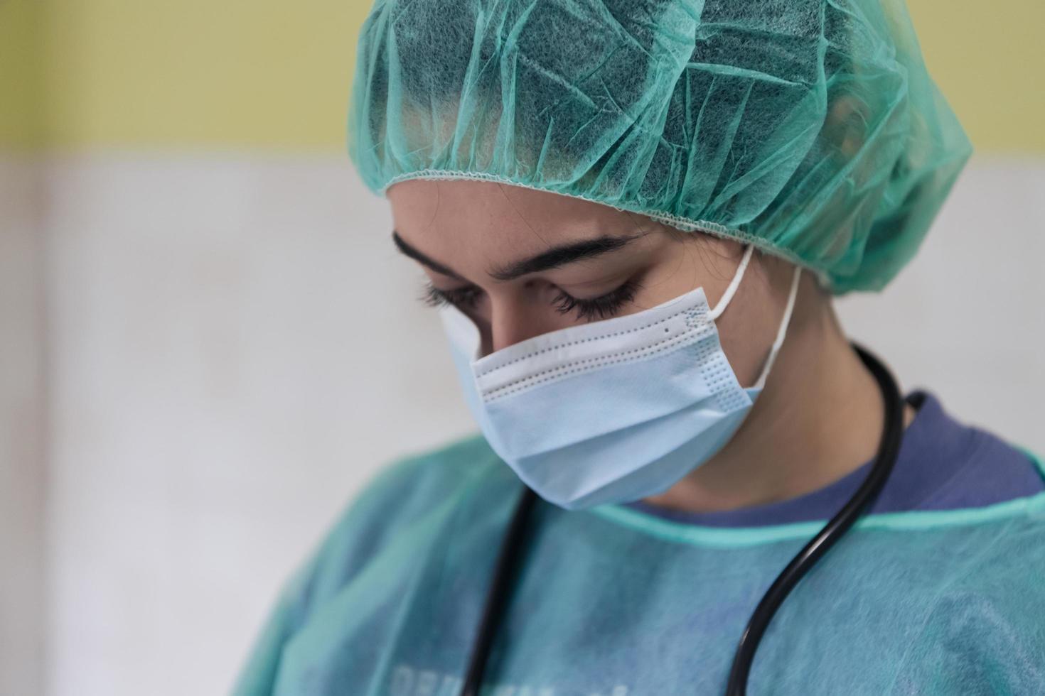 Portrait of sad and overwhelmed doctor wearing protective face mask, looking exhausted depressed and worried due to coronavirus outbreak. Emotional stressed, health care workers and COVID-19. photo