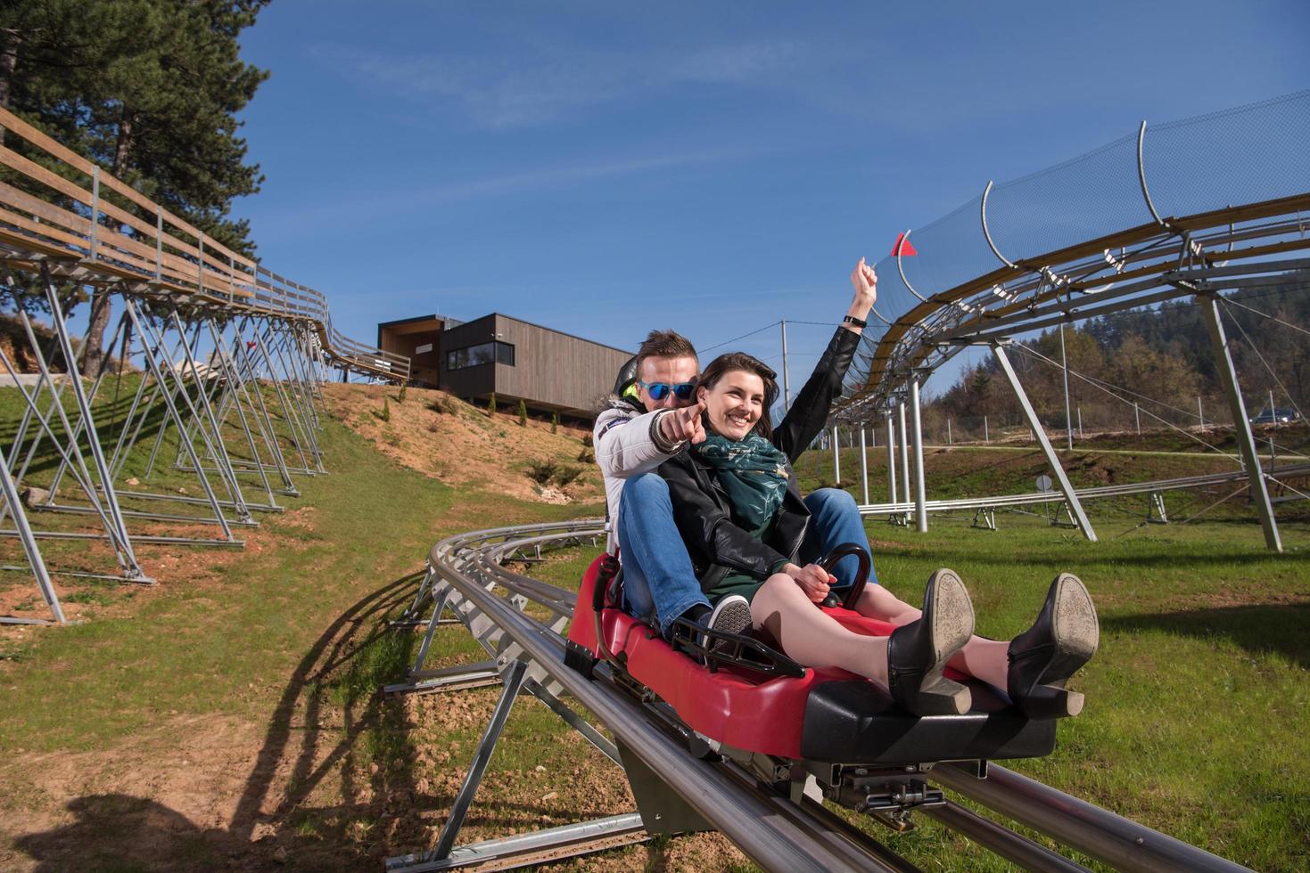 couple enjoys driving on alpine coaster photo