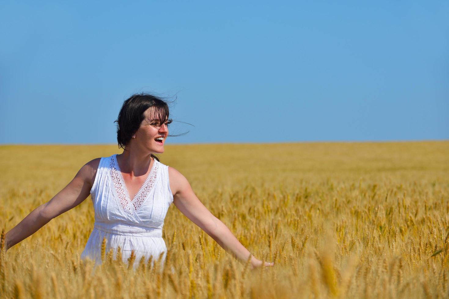 young woman in wheat field at summer photo