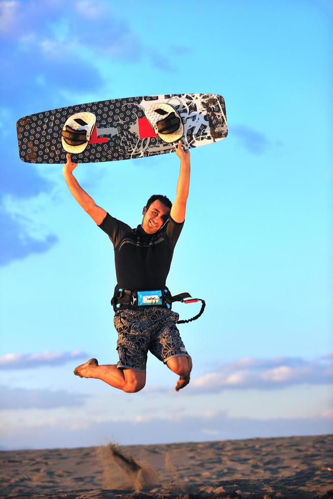 Portrait of a young  kitsurf  man at beach on sunset photo