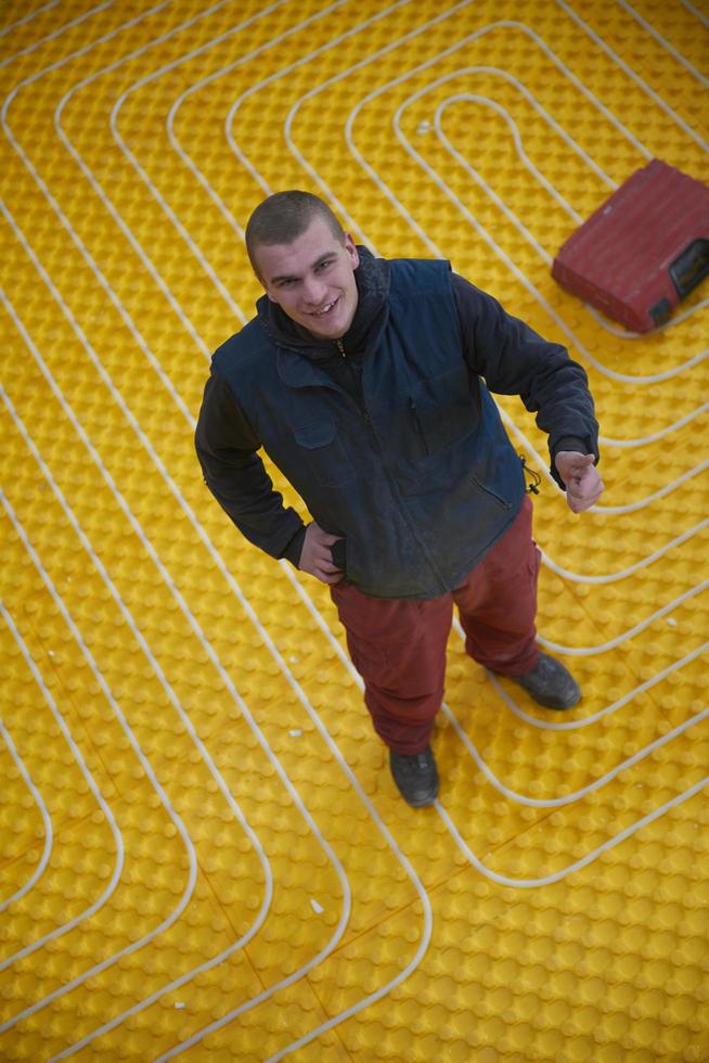 workers installing underfloor heating system photo