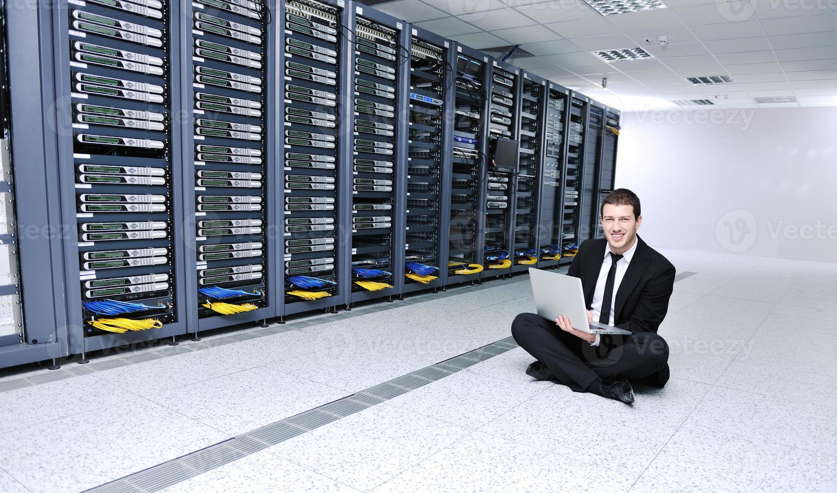 businessman with laptop in network server room photo