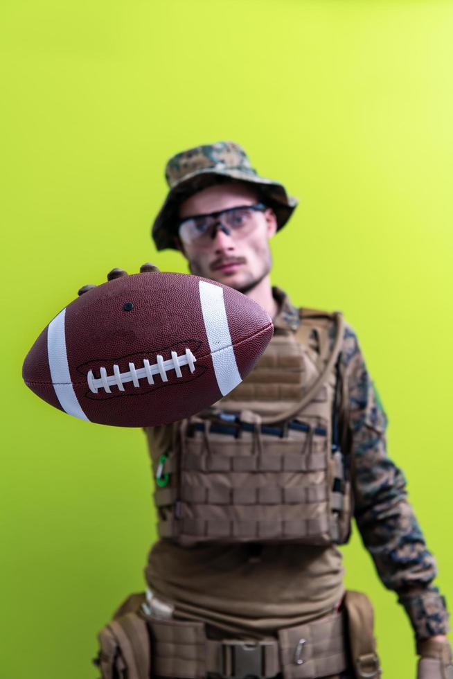 solder holding american football ball photo