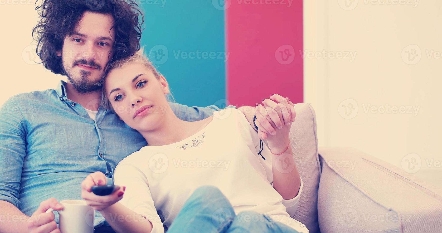 Young couple on the sofa watching television photo