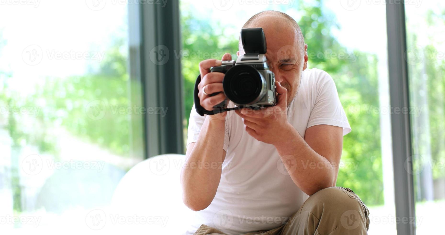 Photographer takes pictures with DSLR camera photo