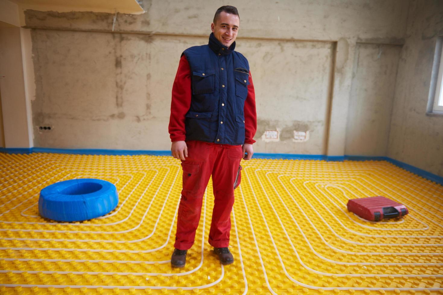 workers installing underfloor heating system photo