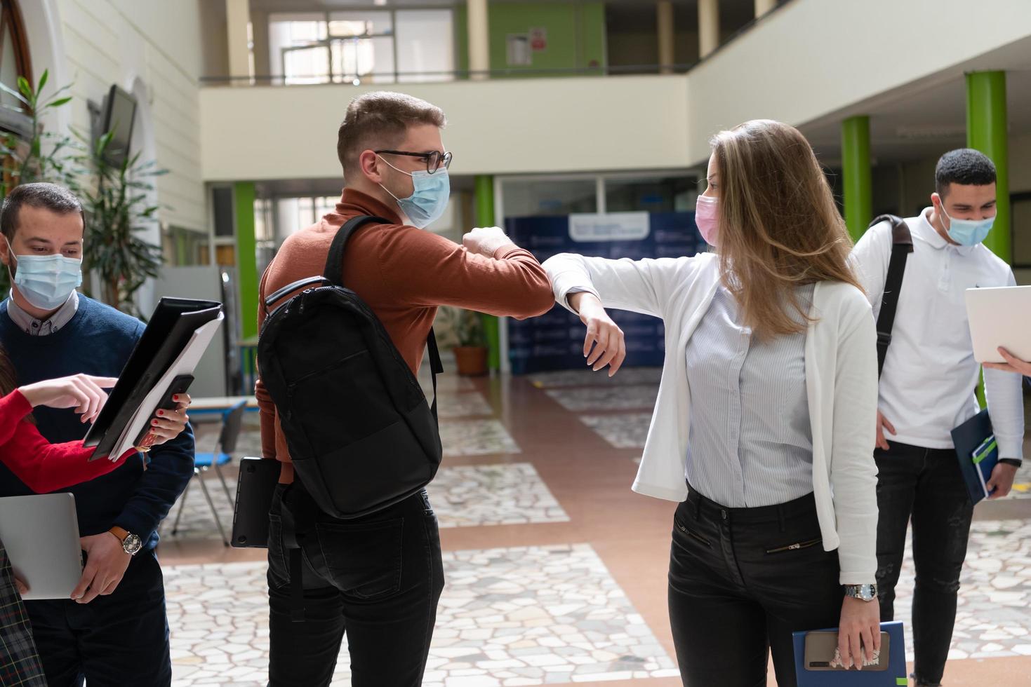 students greeting new normal coronavirus handshake and elbow bumping photo
