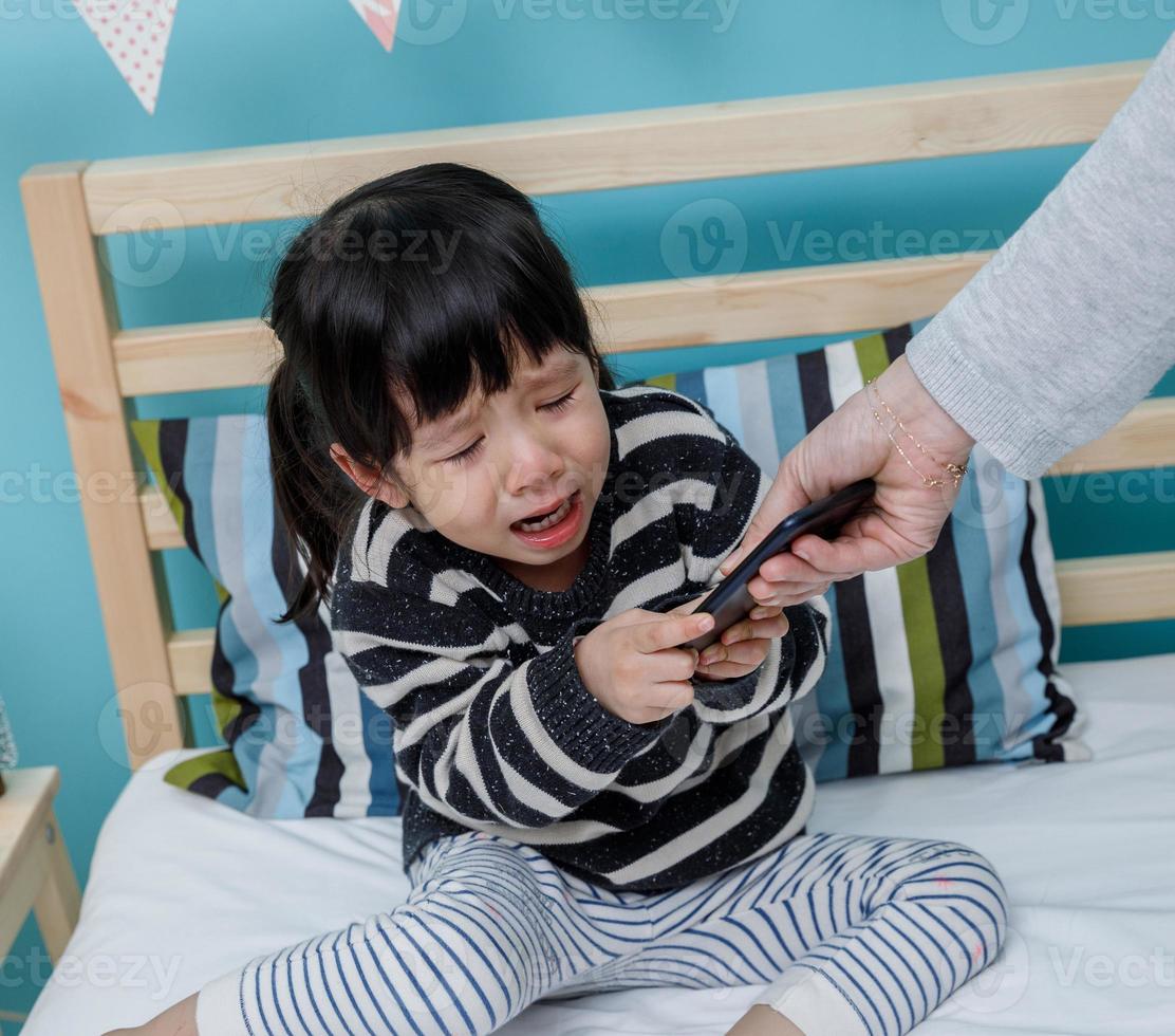 Her mother hold the phone with a crying child. Do not use the smartphone photo