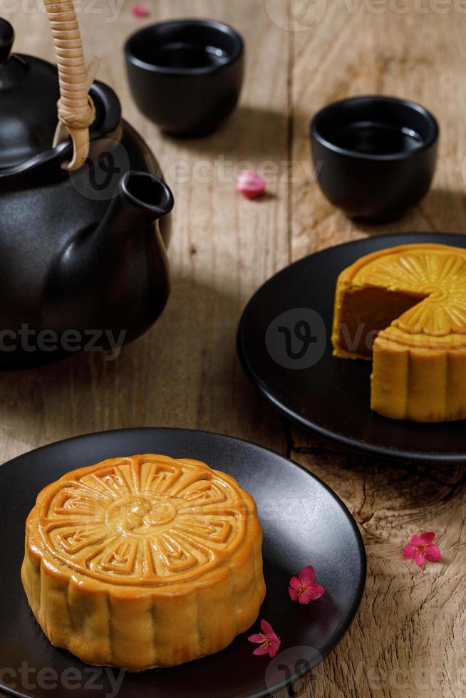 Delicious food moon cake with cup of hot tea on the the wooden table background with copyspace for your text, Chinese traditional festival concept photo