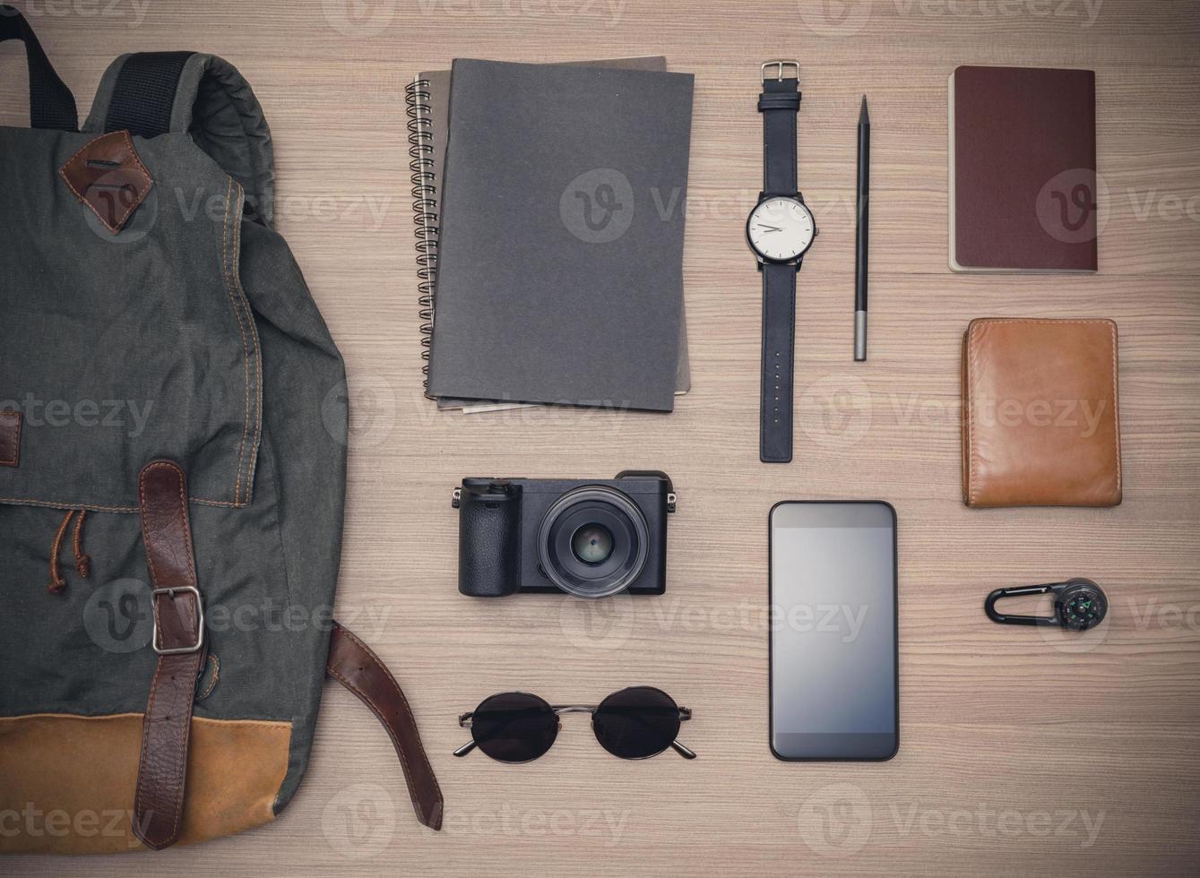 Traveler's accessories with passport, books of travel plan, wallet, camera, campass, backpack and mobile phone on oak wooden table, Flat lay with copy space, Travel concept background photo