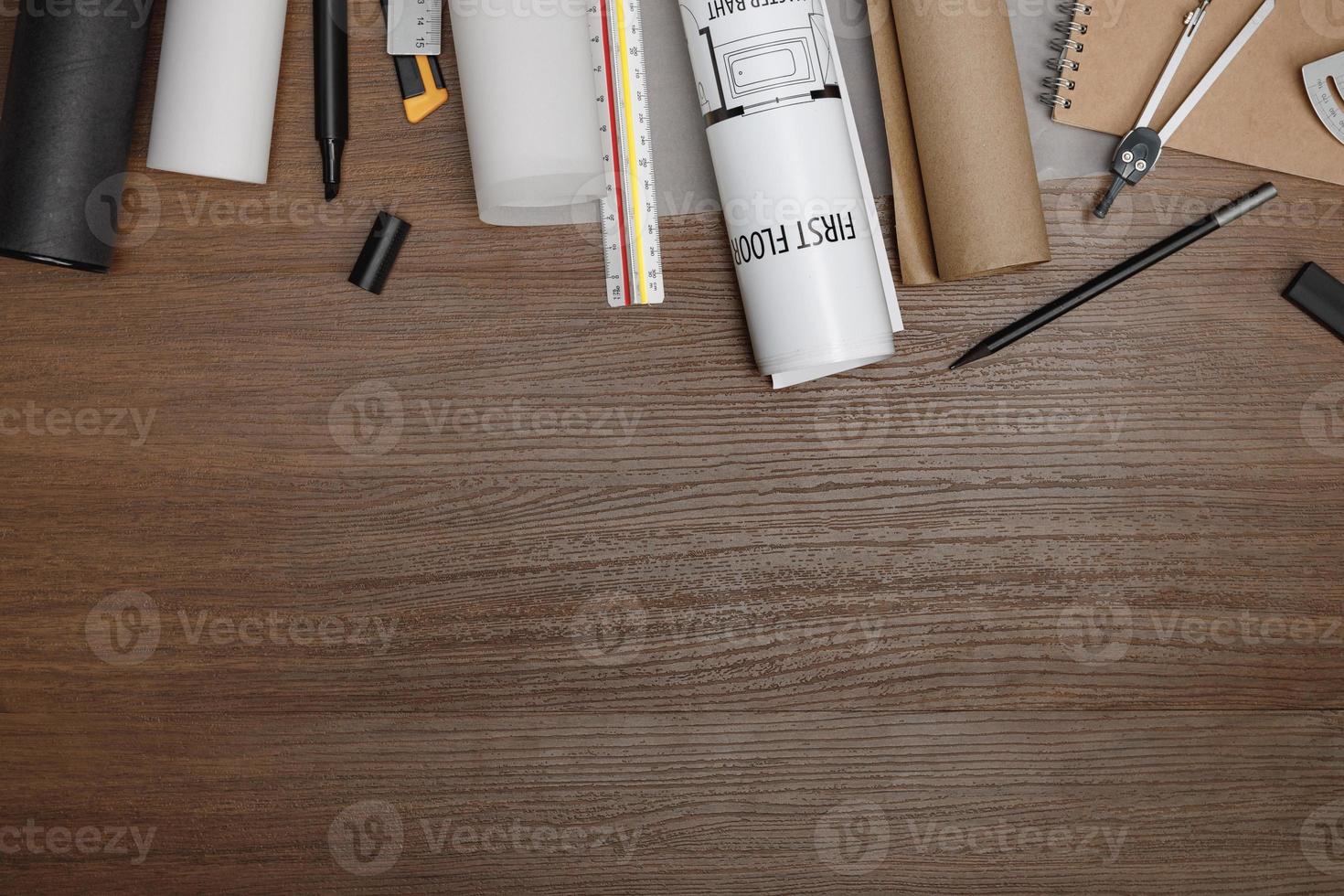 plano creativo de mesa de madera de arquitectos con planos de rollo, plan de proyecto arquitectónico, herramientas de ingeniería, suministros de oficina, espacio de trabajo para el concepto de diseñador foto