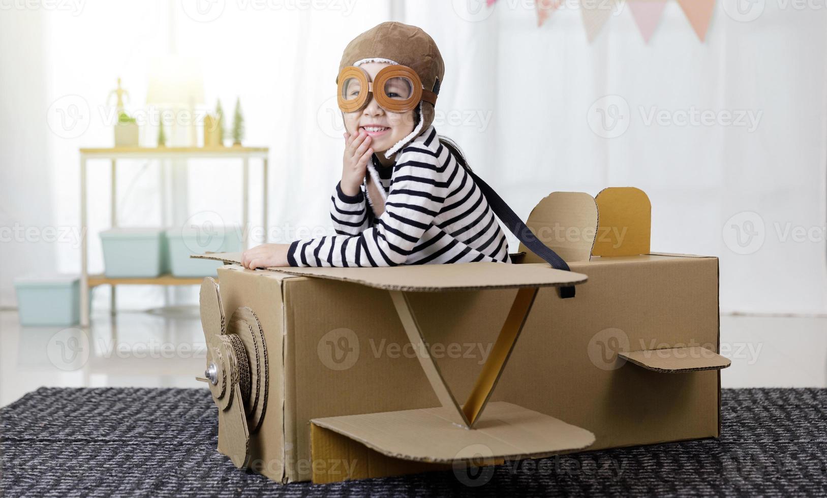 Asian little child girl playing with cardboard toy airplane handicraft isolated in home long banner with copy space for your text, Creative with family and dreaming of flying concept photo