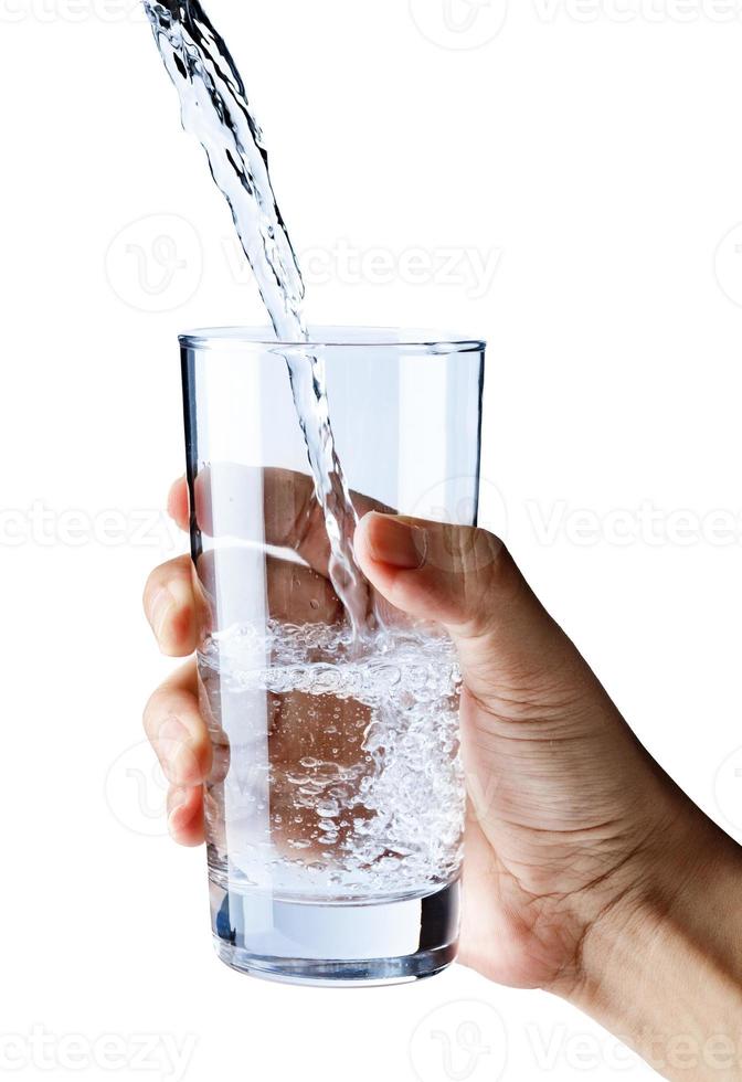 Pouring water into glass in hand isolated on white background, Healthcare and beauty hydration concept photo