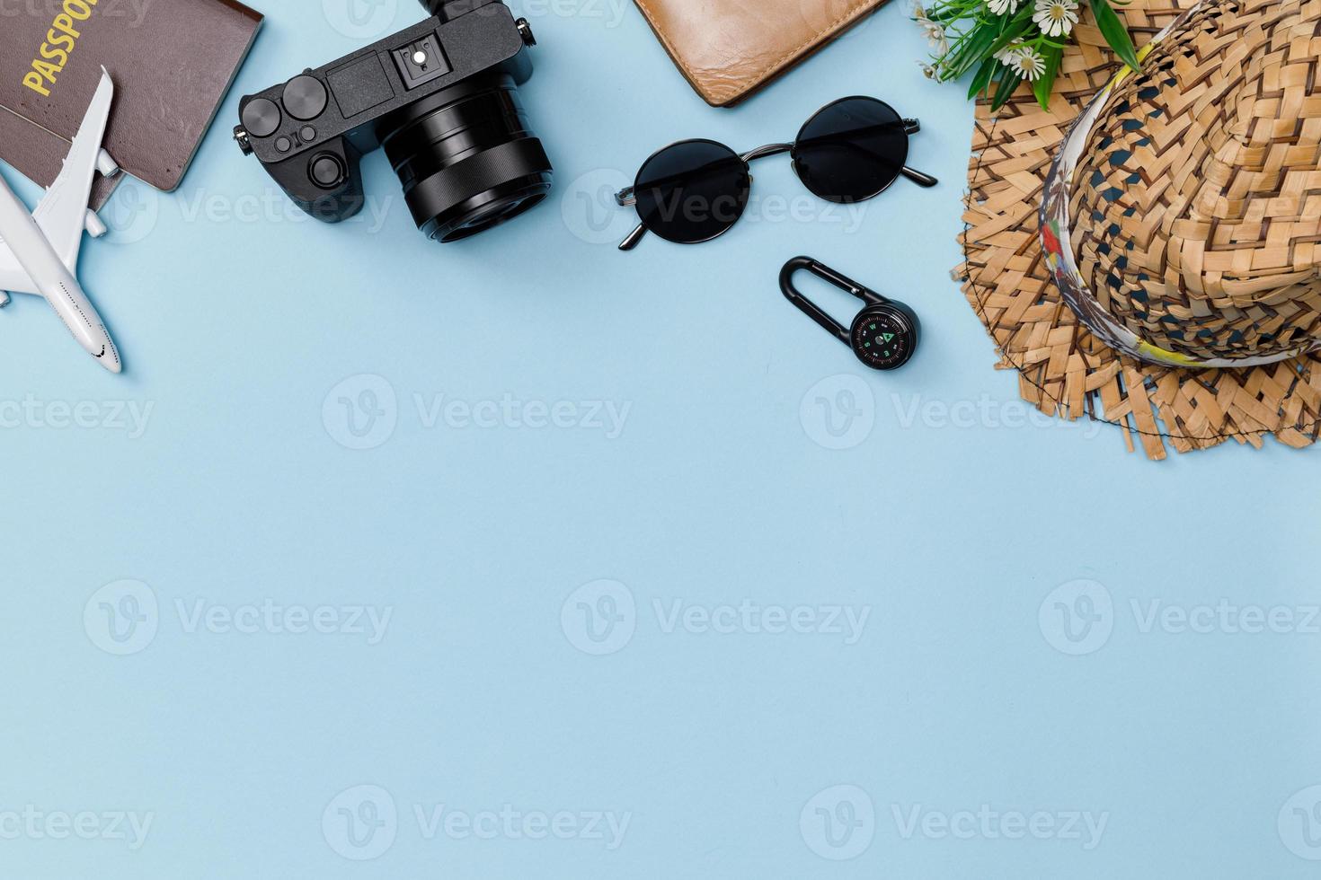 Top view mockup of Traveler's accessories with passport, compass, wallet, camera, hat and airplane toy isolated colorful blue background with empty space, Tropical travel concept photo