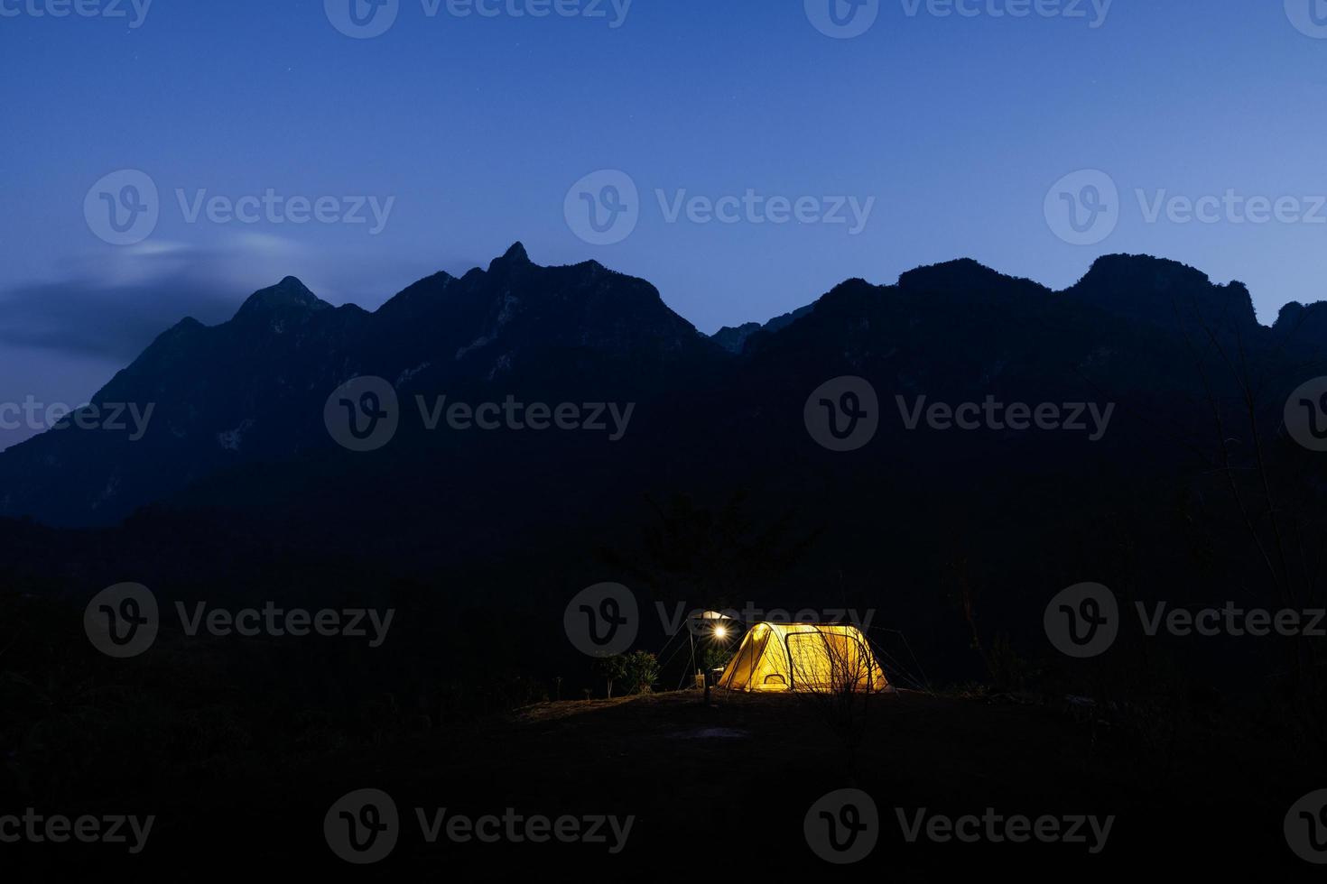 Glowing yellow tent in the mountains with cloud in natural park, Tourism concept photo