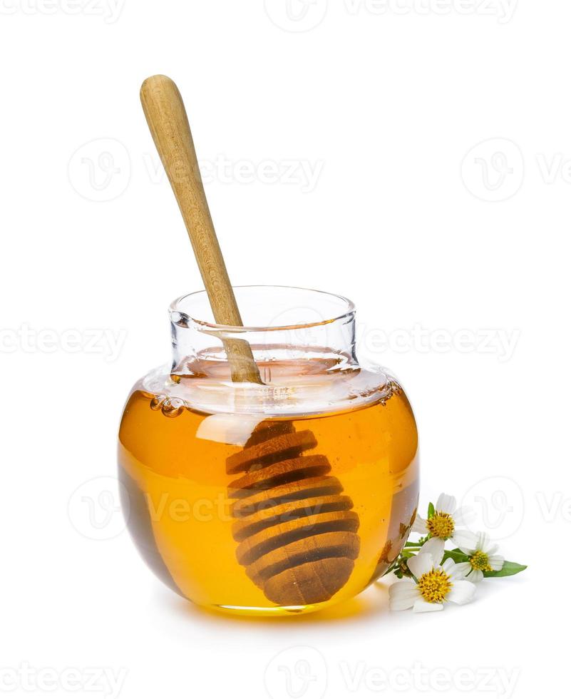 Honey bee in jar with honey dipper and flower isolate on white background, bee products by organic natural ingredients concept photo