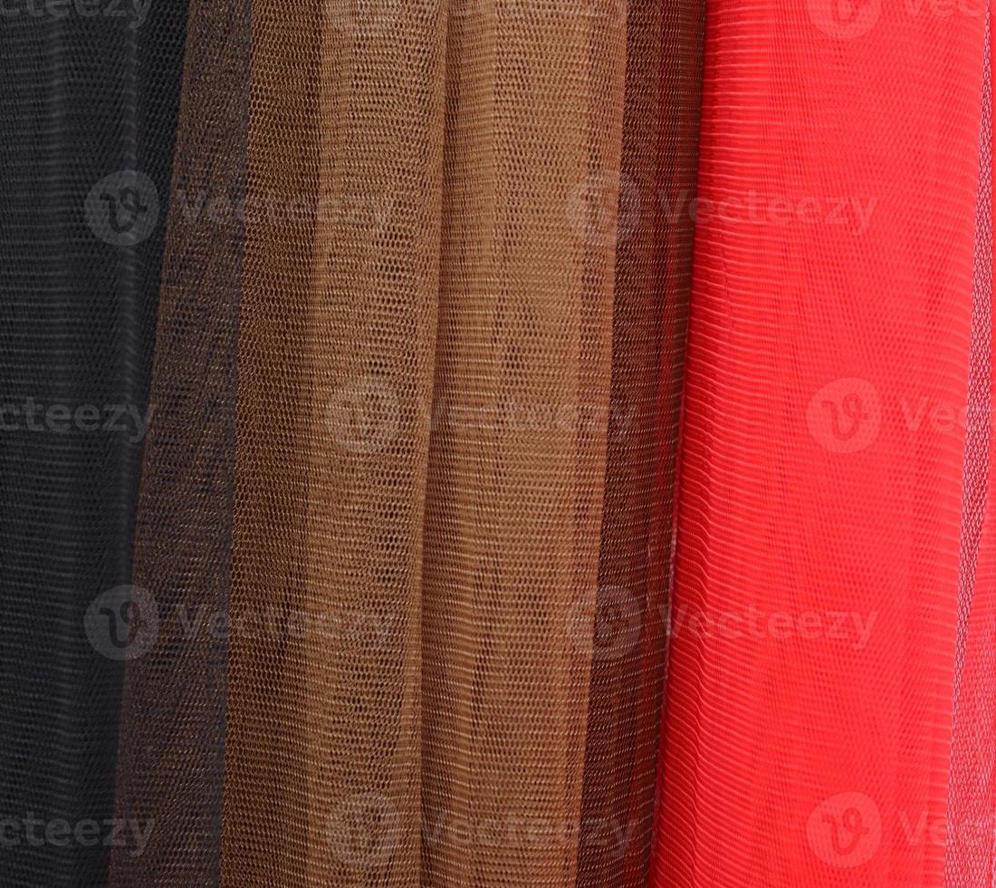 Detailed close up view on samples of cloth and fabrics in different colors found at a fabrics market photo