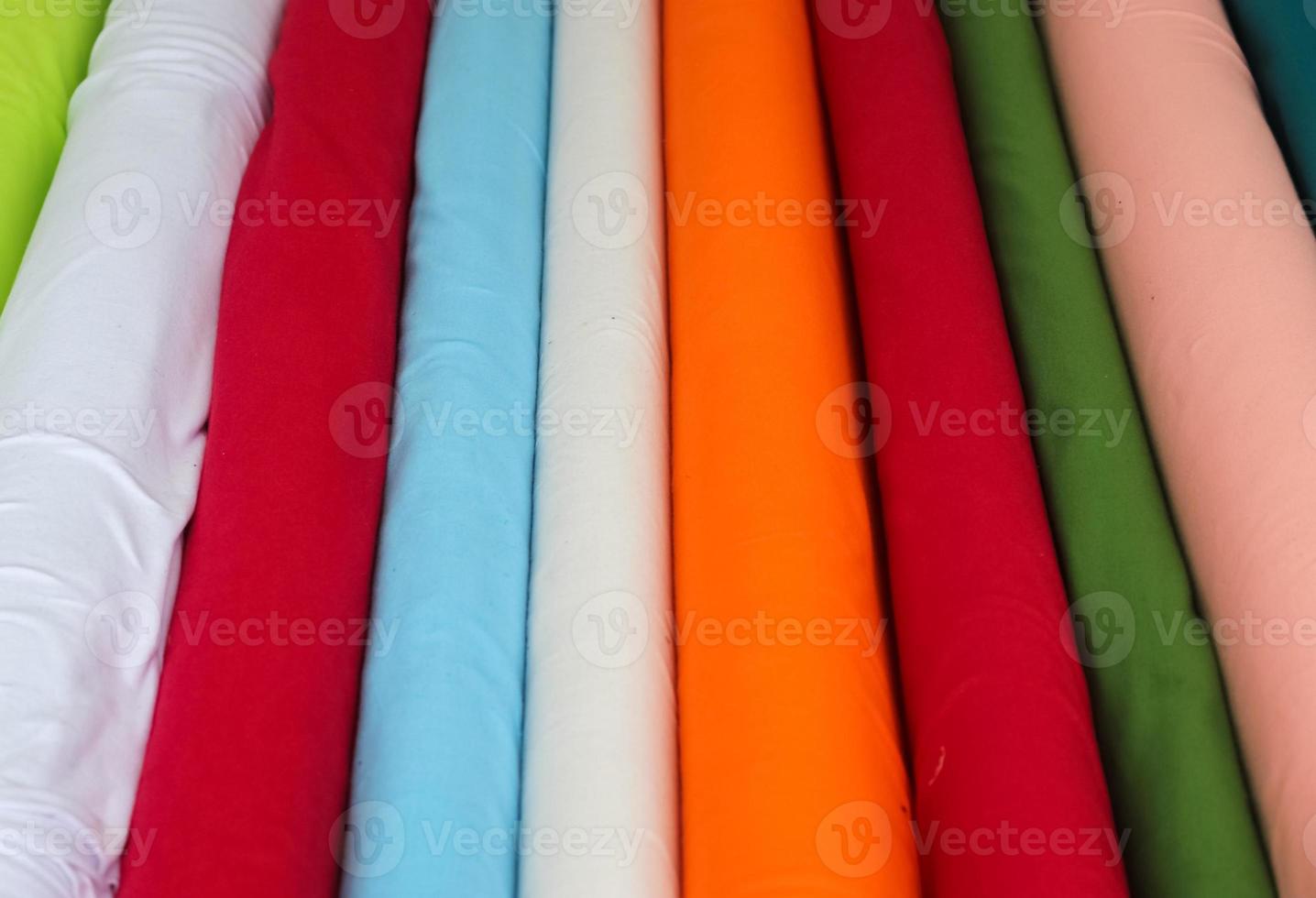 Detailed close up view on samples of cloth and fabrics in different colors found at a fabrics market photo