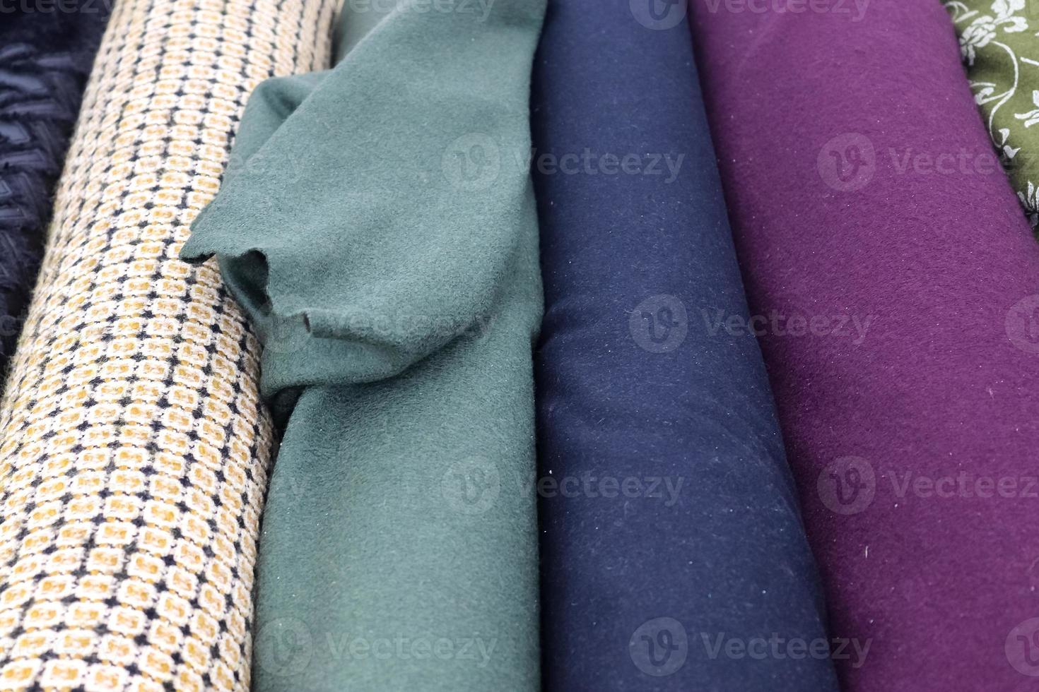 Detailed close up view on samples of cloth and fabrics in different colors found at a fabrics market photo