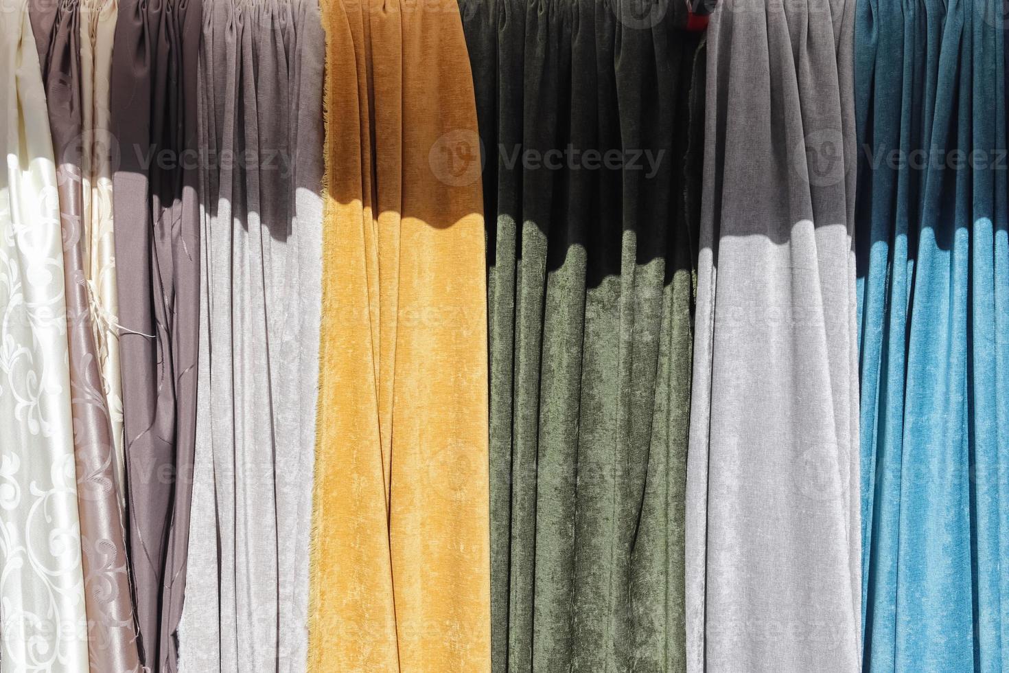 Detailed close up view on samples of cloth and fabrics in different colors found at a fabrics market photo