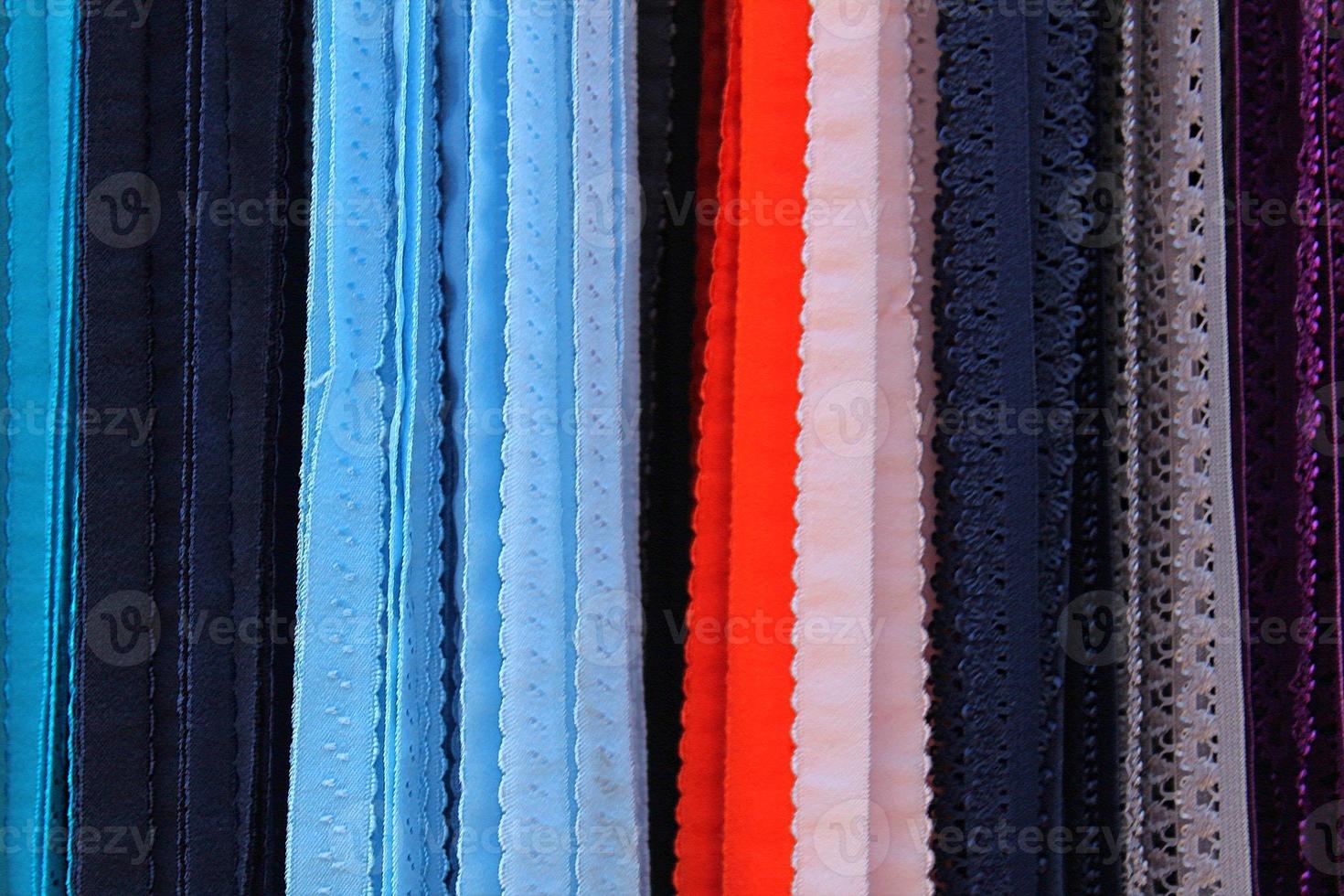 Detailed close up view on samples of cloth and fabrics in different colors found at a fabrics market photo