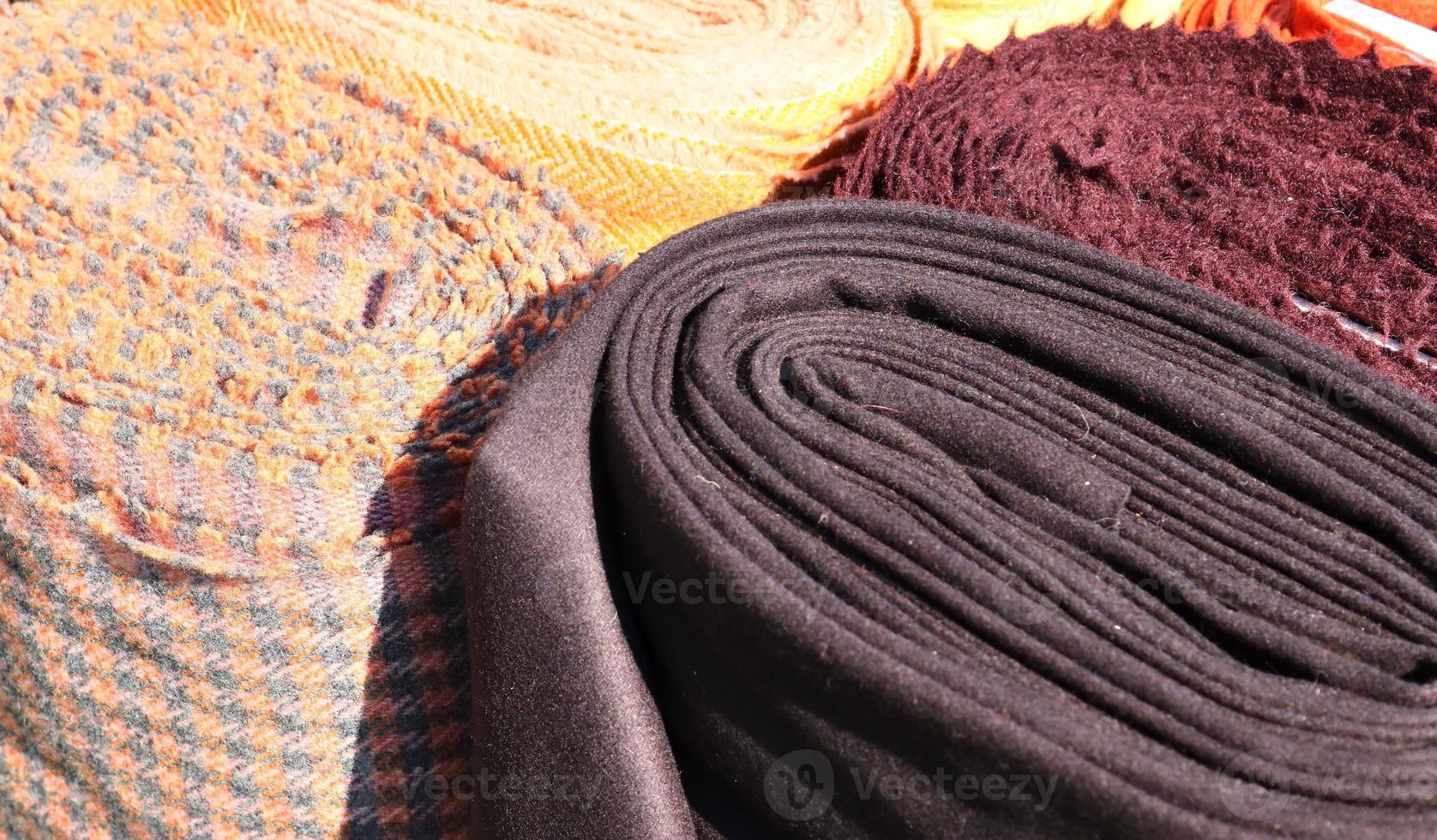 Detailed close up view on samples of cloth and fabrics in different colors found at a fabrics market photo