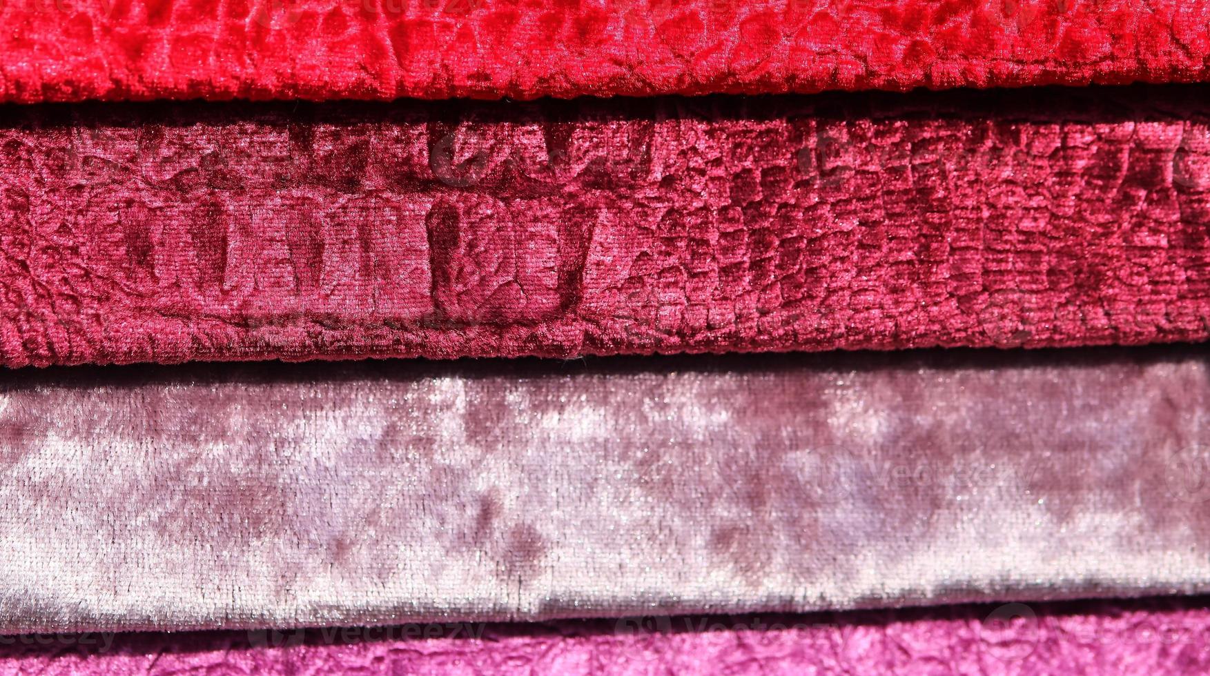 Detailed close up view on samples of cloth and fabrics in different colors found at a fabrics market photo