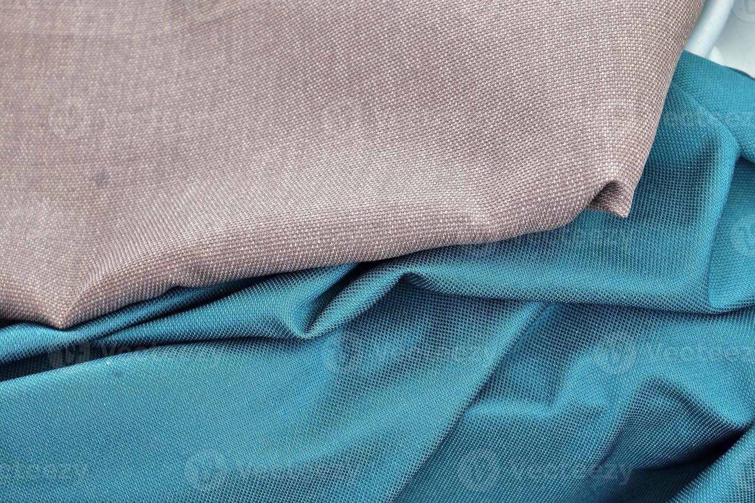 Detailed close up view on samples of cloth and fabrics in different colors found at a fabrics market photo