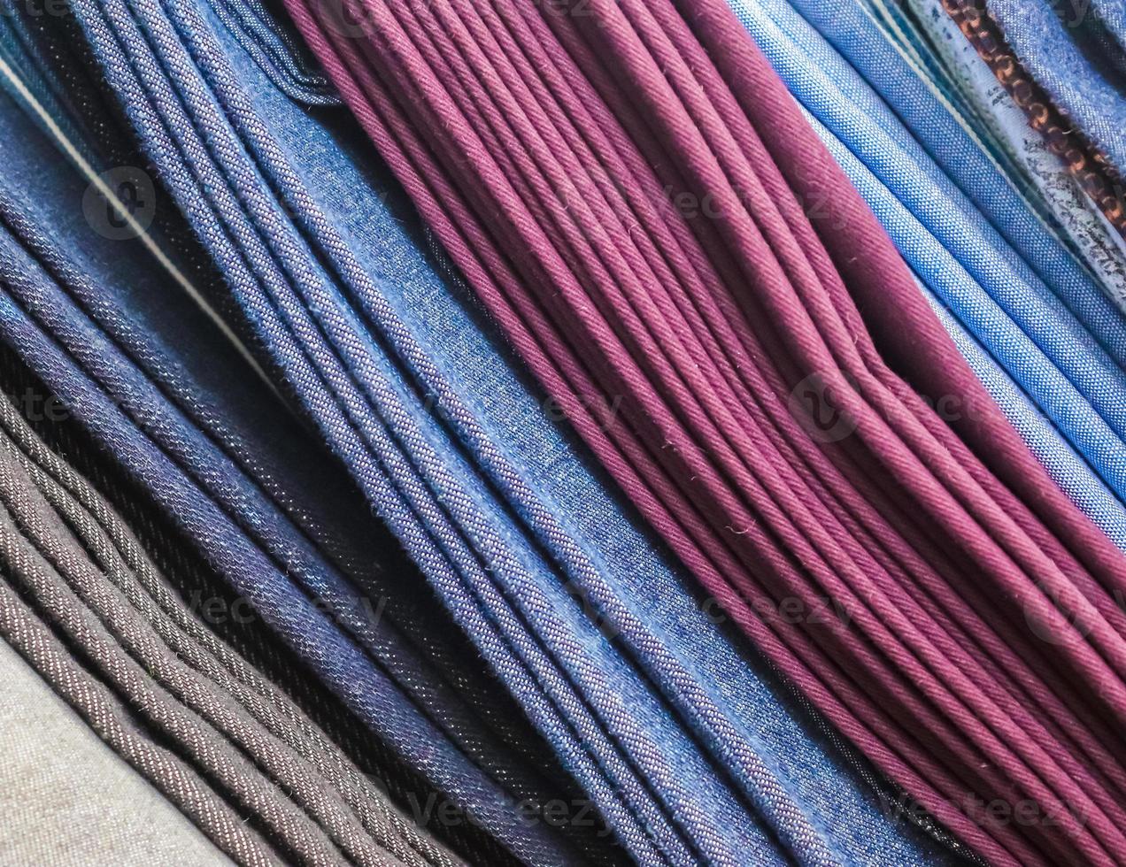 Detailed close up view on samples of cloth and fabrics in different colors found at a fabrics market photo