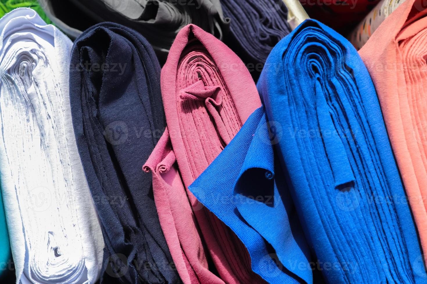 Detailed close up view on samples of cloth and fabrics in different colors found at a fabrics market photo