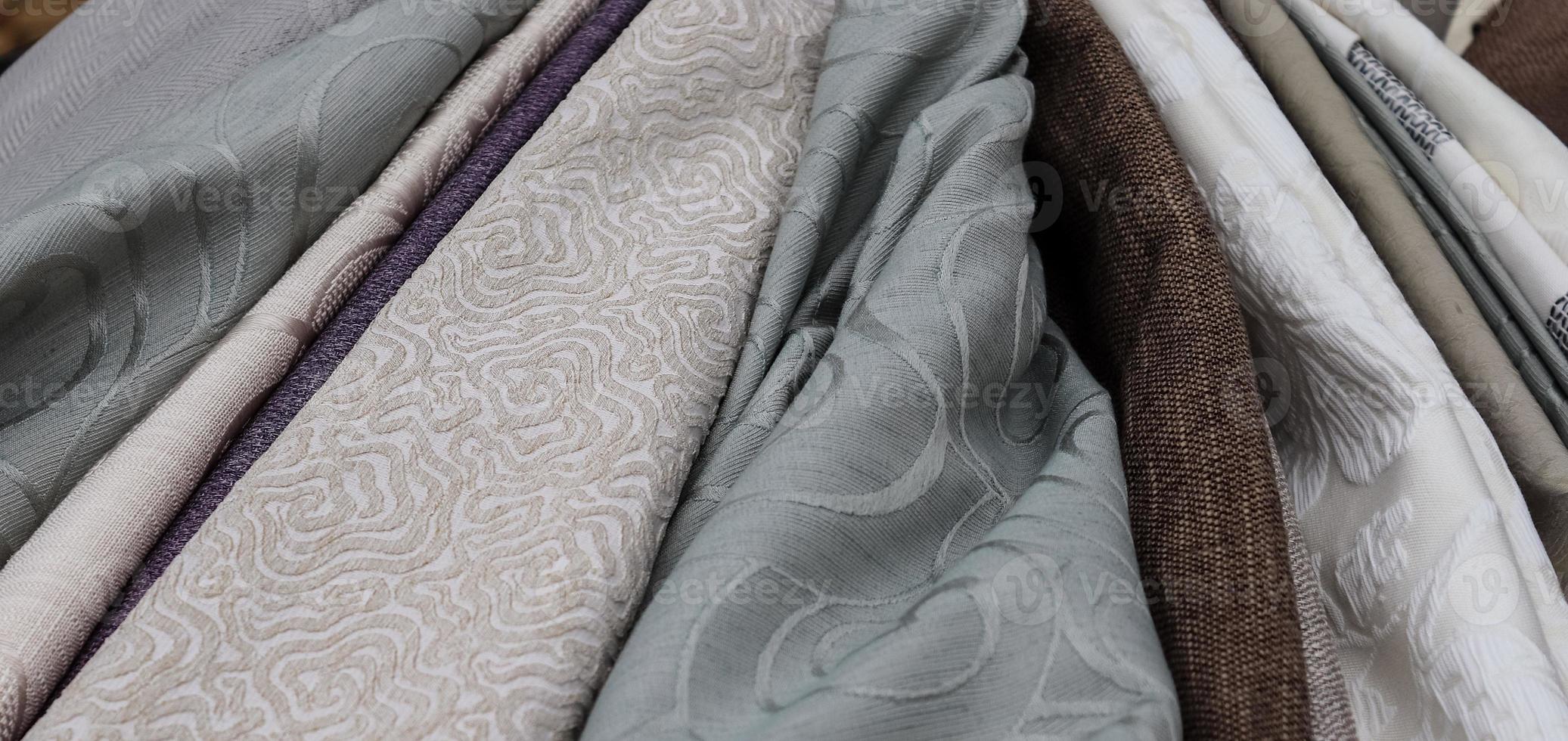 Detailed close up view on samples of cloth and fabrics in different colors found at a fabrics market photo