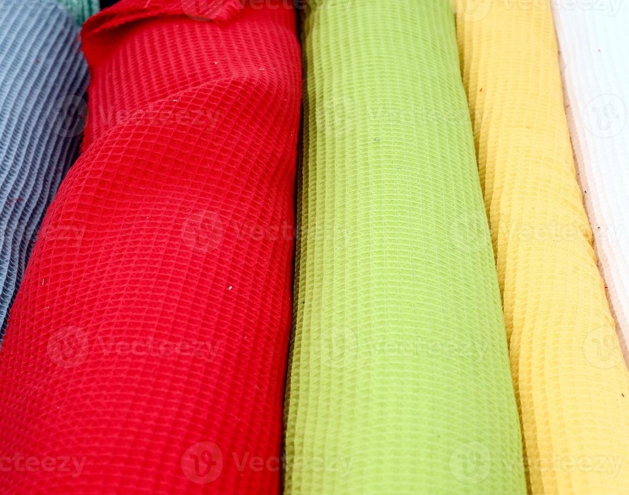 Detailed close up view on samples of cloth and fabrics in different colors found at a fabrics market photo