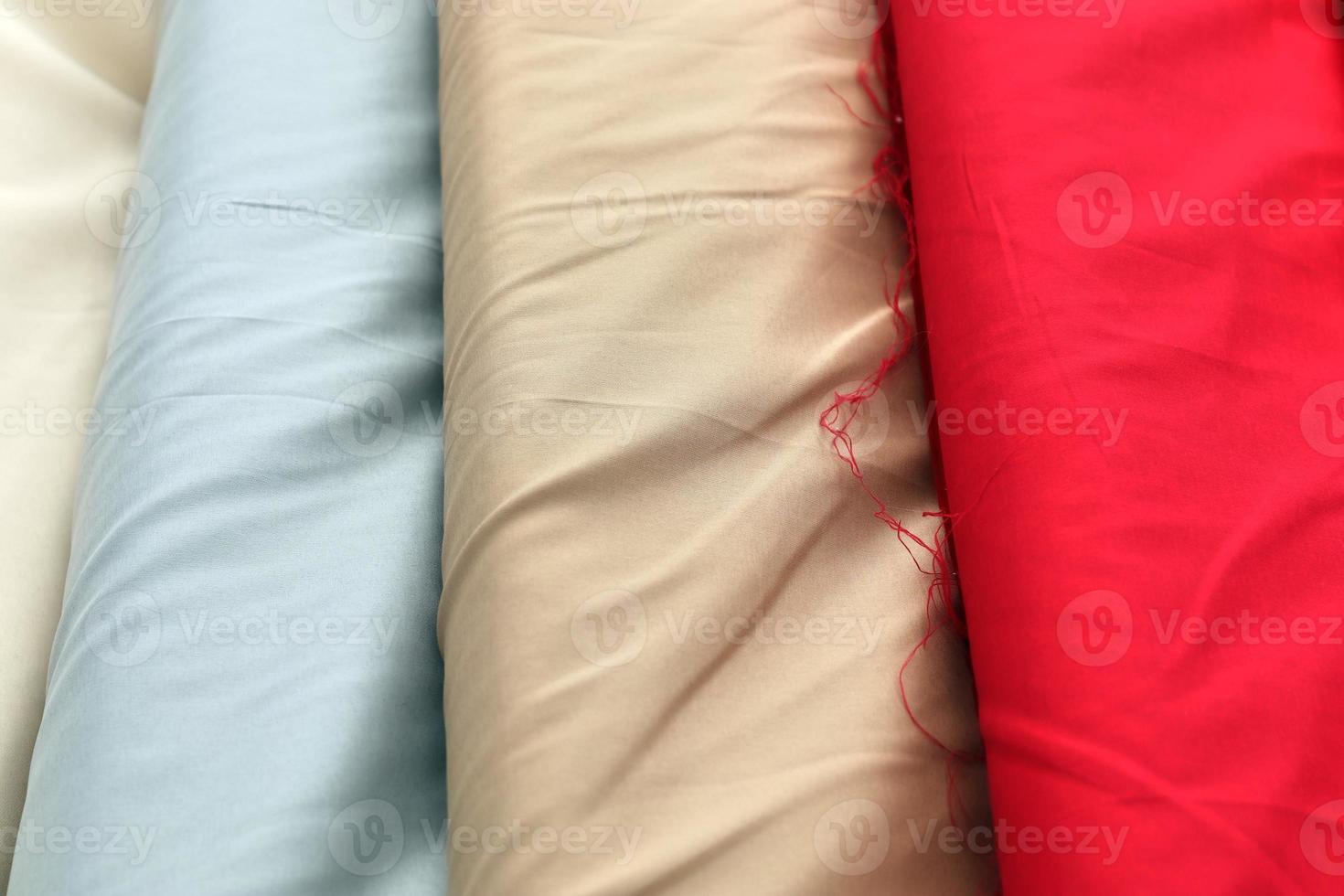 Detailed close up view on samples of cloth and fabrics in different colors found at a fabrics market photo