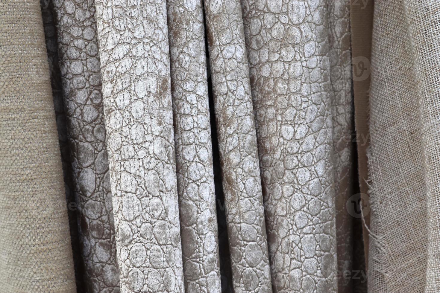 Detailed close up view on samples of cloth and fabrics in different colors found at a fabrics market photo