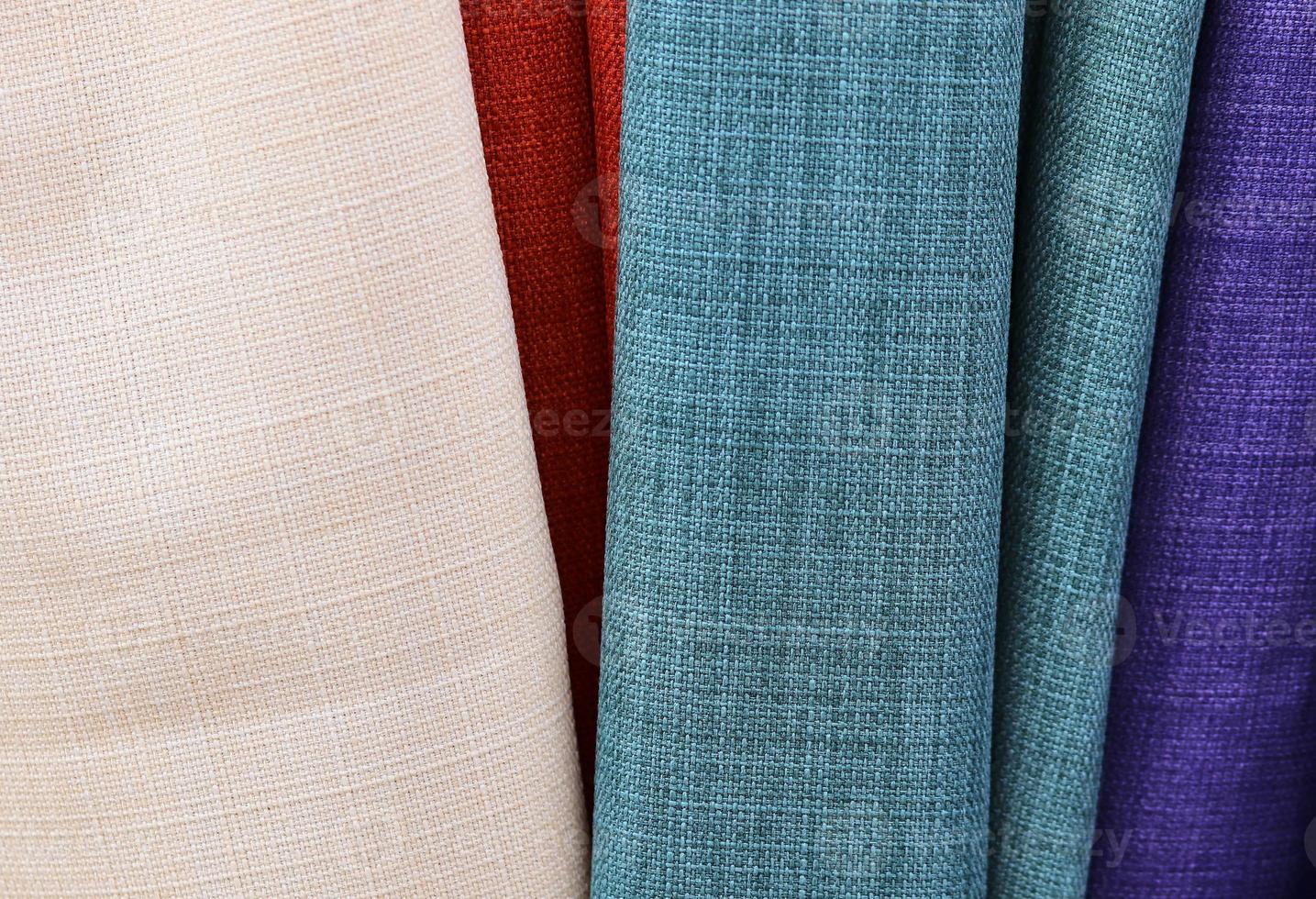Detailed close up view on samples of cloth and fabrics in different colors found at a fabrics market photo