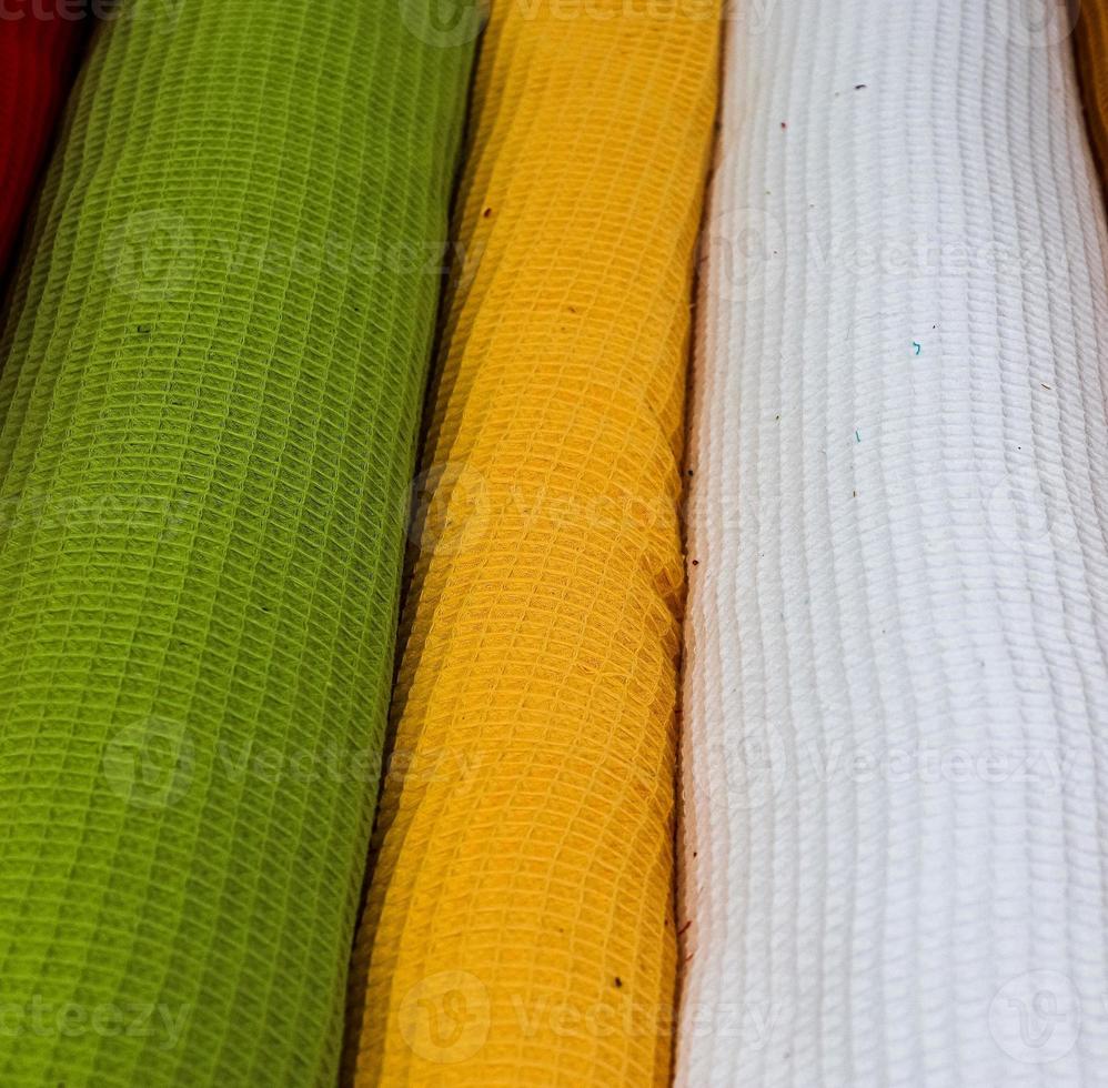Detailed close up view on samples of cloth and fabrics in different colors found at a fabrics market photo