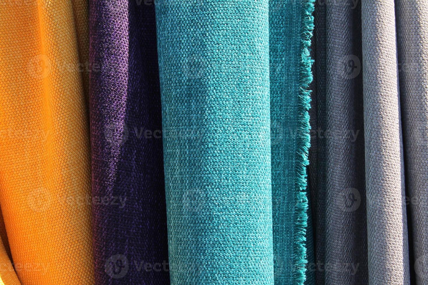 Detailed close up view on samples of cloth and fabrics in different colors found at a fabrics market photo