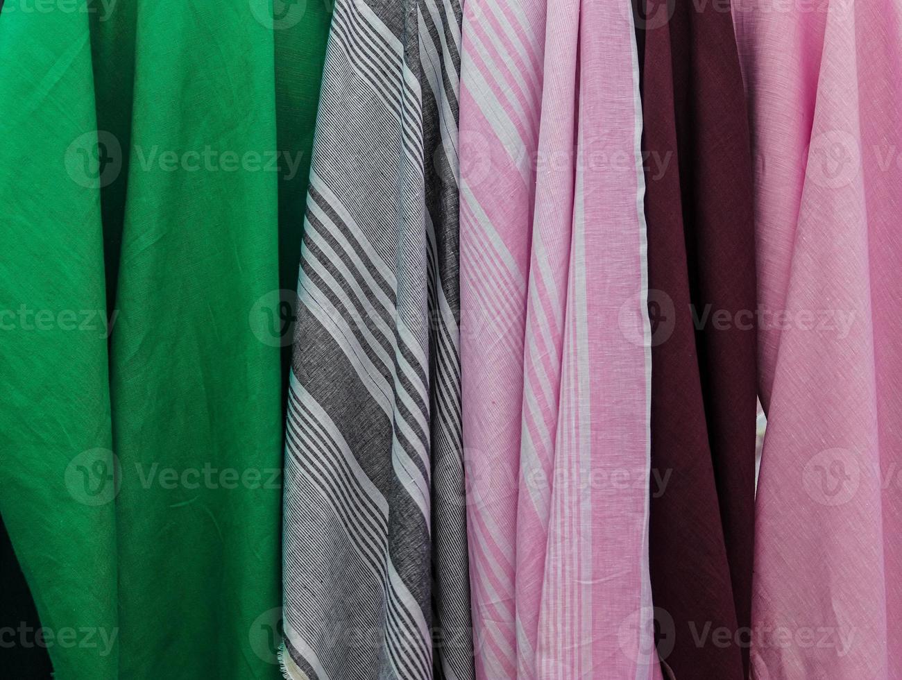 Detailed close up view on samples of cloth and fabrics in different colors found at a fabrics market photo