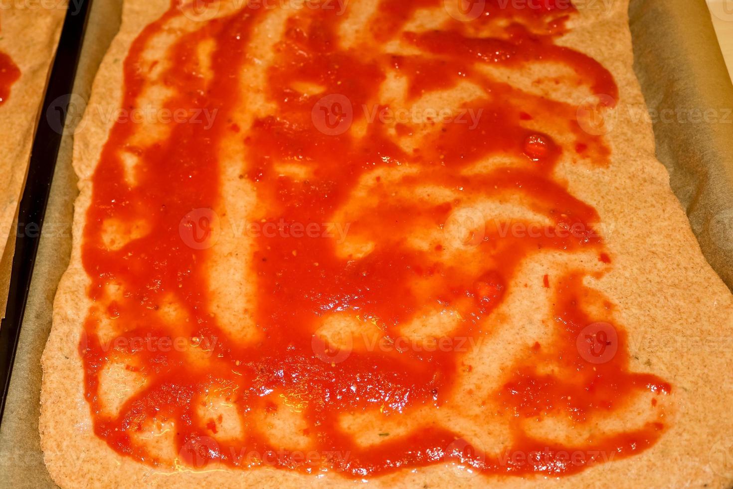 Homemage pizza dough with tomatoe sauce and no topping. photo